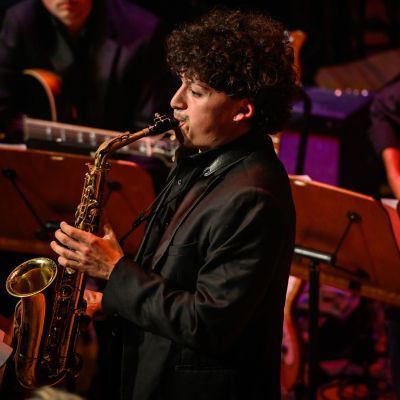 Student playing the saxophone on stage as part of the Jazz ensembles concert